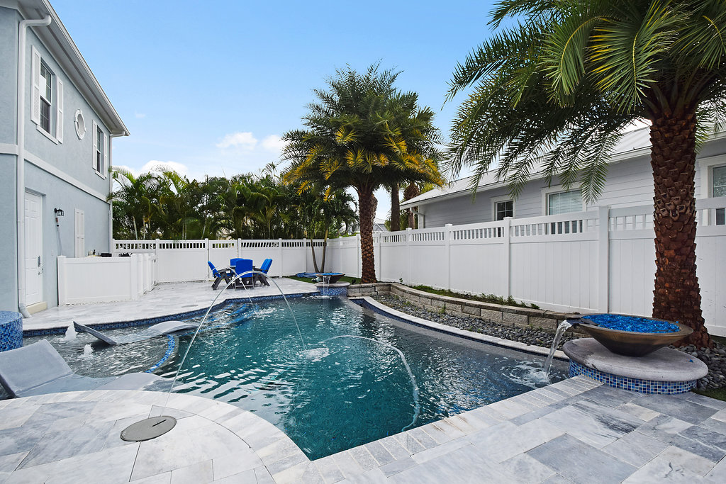 A pool with water jets and palm trees in the background.