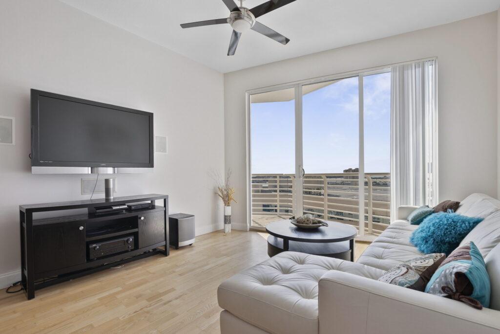 A living room with a large window and a flat screen tv.