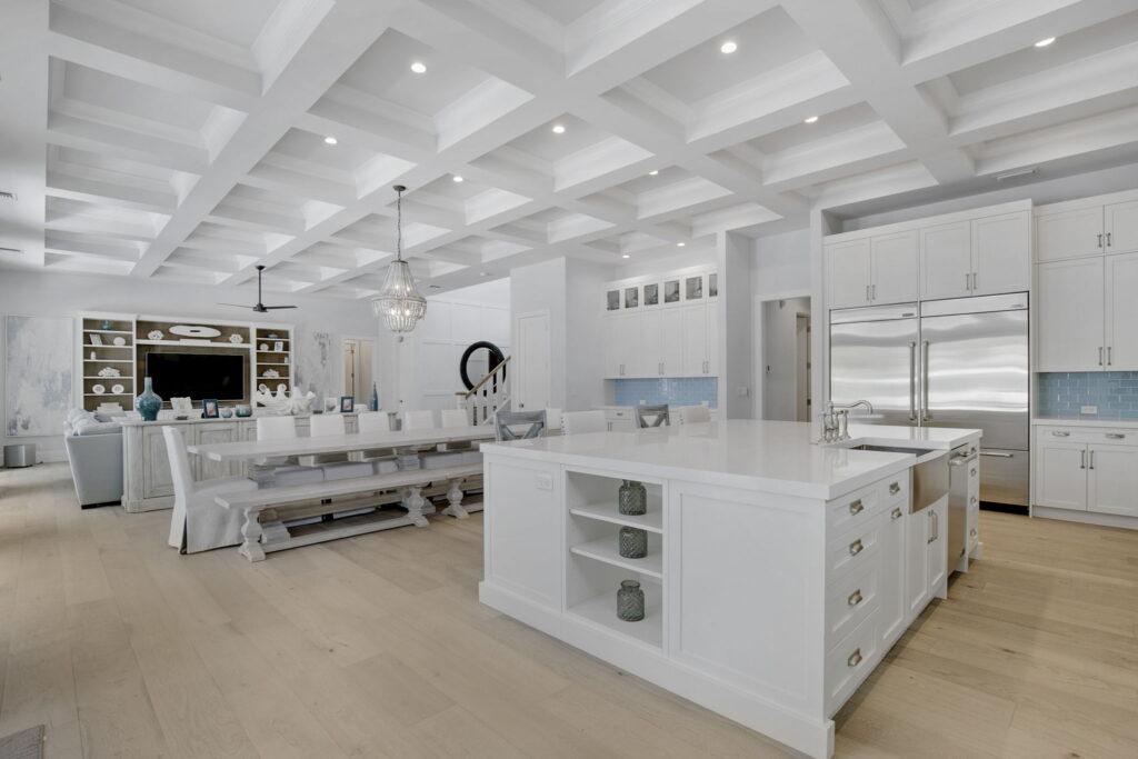 A large white kitchen with a big island in the middle of it