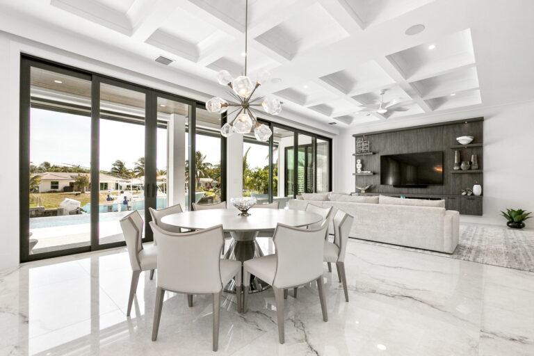 A dining room with white chairs and a table